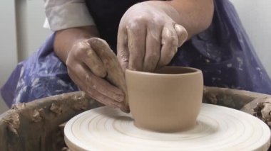 Profesyonel çömlekçi seramikçi elleri çömlekçi çarkında kil çömlek kalıbı döker. Geleneksel çömlek sanatı.