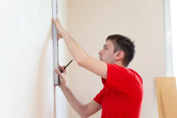 Homme réparateur vérifiant le niveau du mur avec l'outil de niveau de bulle. Concept d'appartement de rénovation — Photo