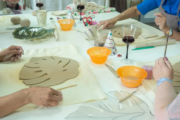 Woman hand potter making clay monstera leaf in pottery workshop studio. Process of creating ceramic vase. Handmade, hobby art and handicraft concept — Stock Photo, Image