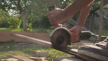 Adam dairesel testereyle çalışıyor. Tahta testereyle. Kapalı çekim yavaş çekim açık havada, güneş ışığında. 