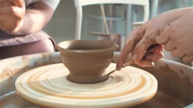 Profesyonel çömlekçi seramikçi elleri çömlekçi çarkında kil çömlek kalıbı döker. Geleneksel çömlek sanatı.