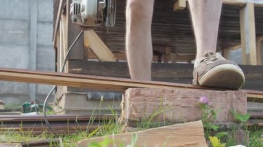 Adam dairesel testereyle çalışıyor. Tahta testereyle. Kapalı çekim yavaş çekim açık havada, güneş ışığında..