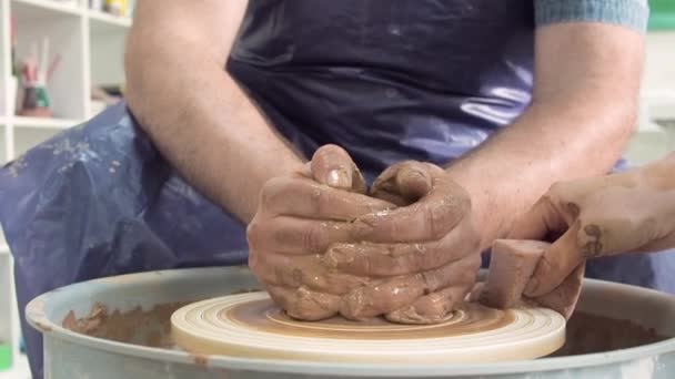 Seorang tukang tembikar membuat mangkuk di atas roda gerabah dari tanah liat di studio keramik dekat. Seni tembikar tradisional. — Stok Video
