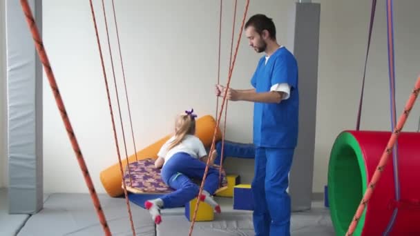 Mädchen Mit Physiotherapeutin Schwingt Während Der Sinnesintegrationseinheit Auf Schaukel Entwicklungsfunktionen — Stockvideo