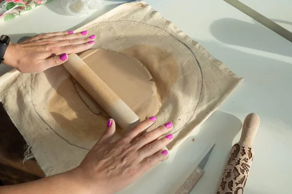 Female ceramist rolls clay using wooden rolling pin in ceramic studio. Close-up hands. Creating pottery — Stock Photo, Image