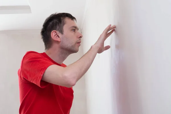 Homme réparateur vérifier ou inspecter le niveau et l'apparence du mur dans le bâtiment. Concept d'appartement de rénovation. — Photo