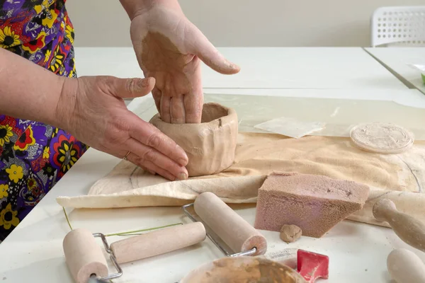 여자 도공 이 도자기 작업장에서 진흙 컵을 만들고 있습니다. 세라믹 머그를 만드는 과정. 수공예, 취미 예술 및 수공예 개념 — 스톡 사진