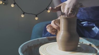 Çömlekçi seramikçi ellerinin kilden dönen kaseyi şekillendirmesine yakın çekim. Geleneksel çömlek sanatı.