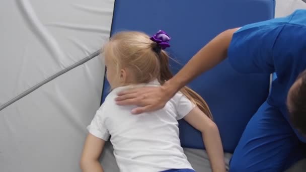 Physiothérapeute massant enfant fille avec une balle nervurée. Intégration sensorielle et dispositif de récupération de sensibilité. — Video