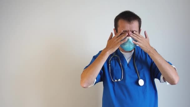 Vermoeide dokter met medisch masker die zijn ogen wrijft. Kopieer ruimte voor tekst. — Stockvideo