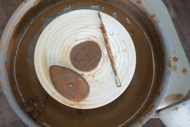 Çömlekçi çarkında kil ile çalıştıktan sonra kirli aletler. boyanmış kalp.