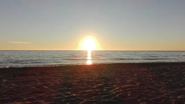 トスカーナのビーチで海の水の上の地平線に太陽のロマンチックな夕日 — ストック写真