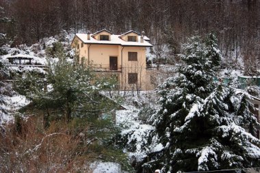 Dağlarda küçük bir kulübe ya da dağ evi kışın yumuşak beyaz karında ve apuan ormanında bir panorama