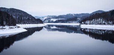 Almanya 'nın Harz Dağları Ulusal Parkı' ndaki Soesetalsperre 'de kış manzarası. Almanya 'da karlı bir hava.