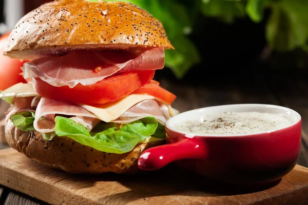 Delicious sandwich with prosciutto ham, cheese and vegetables — Stock Photo, Image