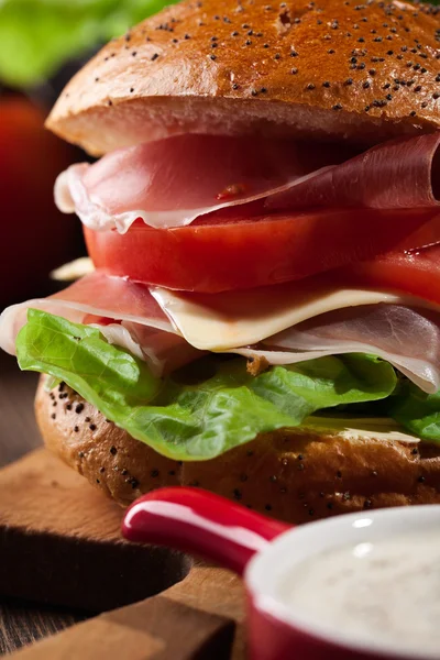 Delicious sandwich with prosciutto ham, cheese and vegetables — Stock Photo, Image