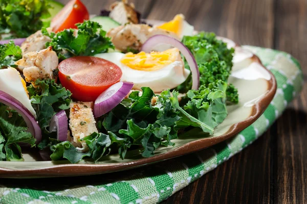 Fräsch sallad med kyckling, tomater, ägg och sallad på tallrik — Stockfoto