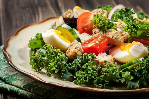 Ensalada fresca con pollo, tomates, huevos y lechuga en el plato —  Fotos de Stock