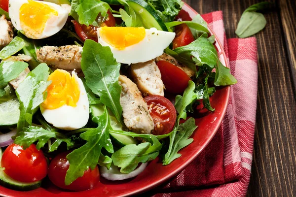 Ensalada fresca con pollo, tomates, huevos y rúcula en el plato —  Fotos de Stock