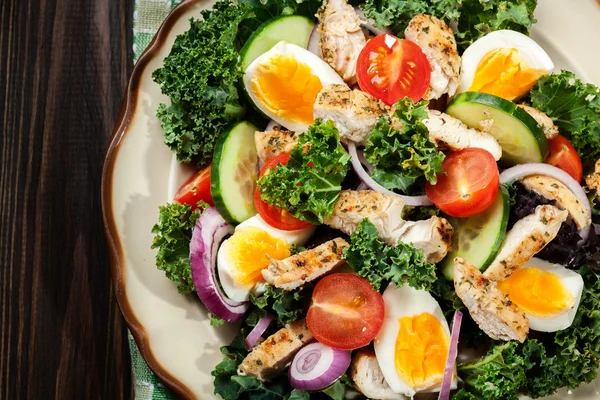 Salade fraîche avec poulet, tomates, œufs et laitue dans l'assiette — Photo