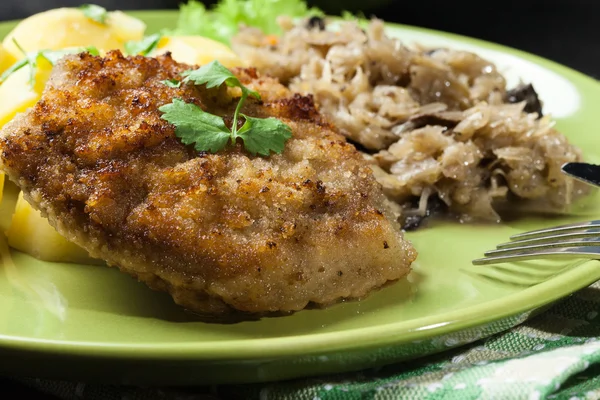 Schnitzel de cerdo frito servido con papas hervidas y sauer frito —  Fotos de Stock