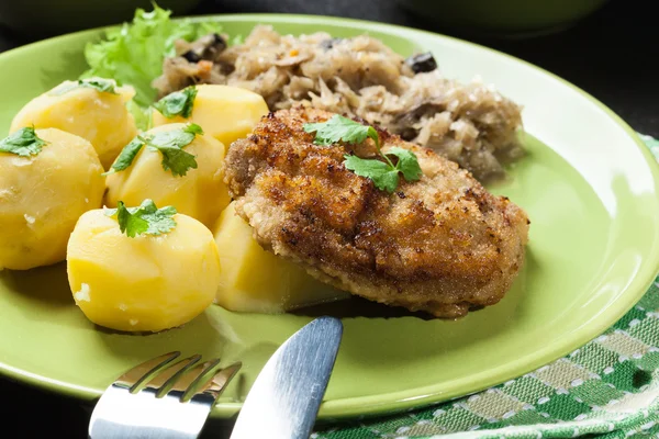 Schnitzel de cerdo frito servido con papas hervidas y sauer frito —  Fotos de Stock