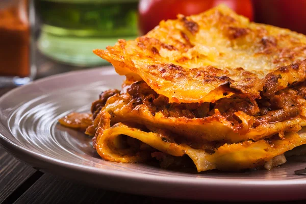 Un trozo de sabrosa lasaña caliente en un plato — Foto de Stock