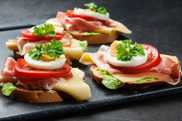 Delicioso sándwich con jamón de jamón, queso, tomate y huevo —  Fotos de Stock