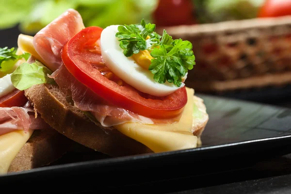 Delicious sandwich with prosciutto ham, cheese, tomato and egg — Stock Photo, Image