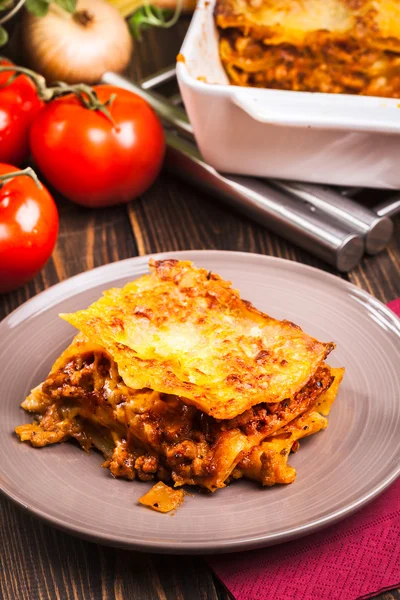 Un trozo de sabrosa lasaña caliente en un plato —  Fotos de Stock