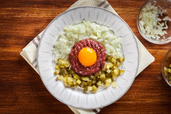 Filete tartar con yema de huevo, cebollas y encurtidos — Foto de Stock