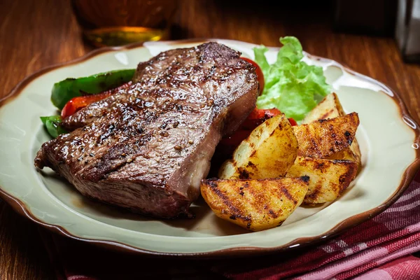Portions of grilled beef steak with grilled potatoes and paprika — Stock Photo, Image