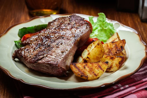 Delar av grillad biff med grillad potatis och paprika — Stockfoto