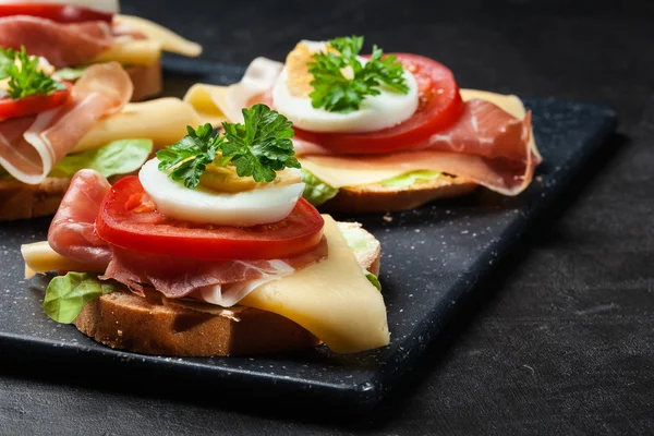 Delicioso sándwich con jamón de jamón, queso, tomate y huevo —  Fotos de Stock