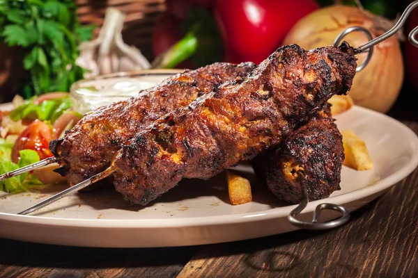 Gegrilde shish kebab geserveerd met gebakken frites en salade — Stockfoto