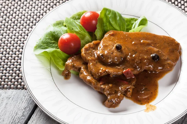 Costeleta de porco com molho e legumes — Fotografia de Stock