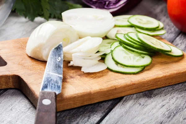 Légumes hachés : oignon et concombre sur planche à découper — Photo