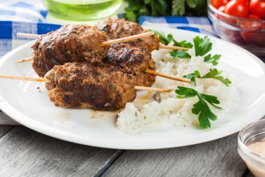 Barbecued kofta with rice on a plate clipart