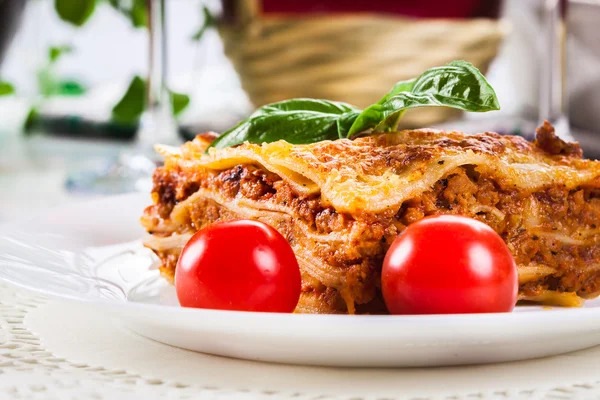 Piece of tasty hot lasagna with red win — Stock Photo, Image