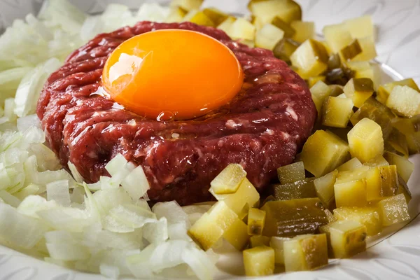 Filete tartar con yema de huevo, cebollas y encurtidos — Foto de Stock