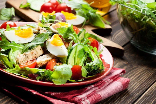 Salade fraîche avec poulet, tomates, œufs et roquette dans l'assiette — Photo