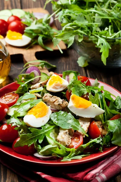 Salada fresca com frango, tomate, ovos e rúcula no prato — Fotografia de Stock