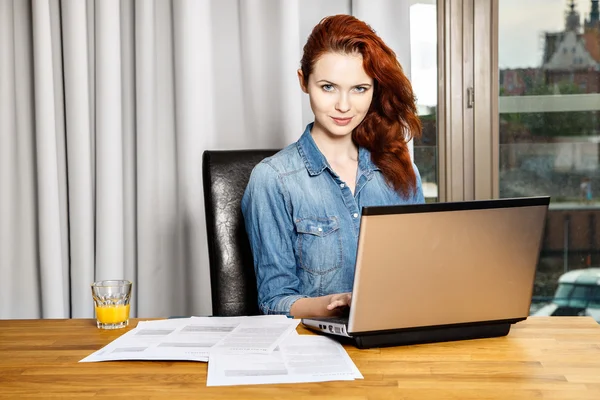 Rödhårig ung business kvinna eller student tjej arbeta med dokument och laptop nära fönster — Stockfoto