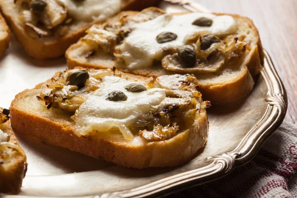 Crostini z smażonymi pieczarkami, cebulą i mozzarellą — Zdjęcie stockowe