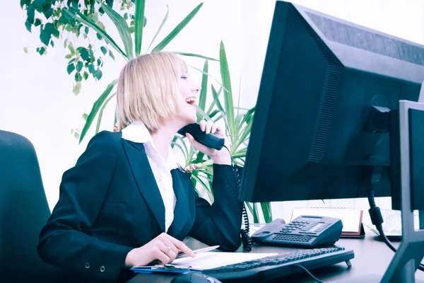 Business concept - Bionda donna d'affari che parla al telefono mentre lavora al computer in ufficio — Foto Stock