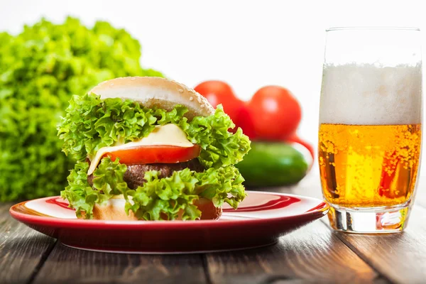 Hamburguesa con queso en un plato con cerveza — Foto de Stock