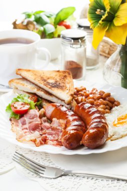 Full English breakfast with bacon, sausage, fried egg and baked  clipart