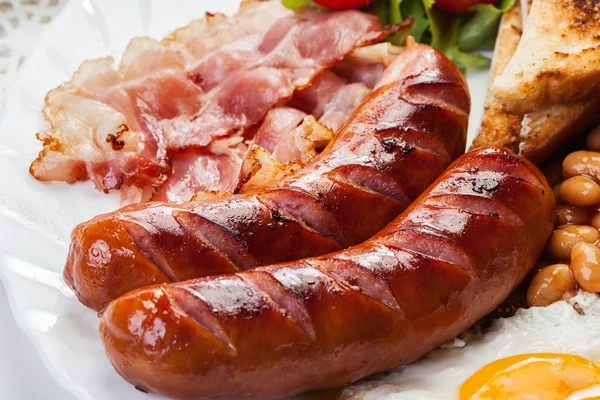 Colazione all'inglese completa con pancetta, salsiccia, uovo fritto e fagioli al forno — Foto Stock