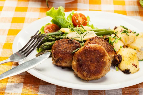 Meatballs served with boiled potatoes and asparagus — Stock Photo, Image