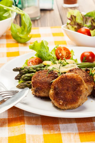 Meatballs served with boiled potatoes and asparagus — Stock Photo, Image